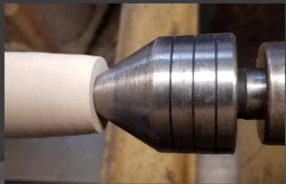 Use a live center to stabilize the piece, typically a 60º cone.